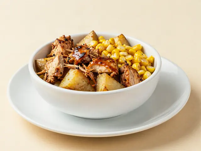 BBQ chicken over roasted potatoes with sweet corn on a plate