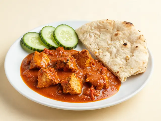 Mild butter chicken with naan wedges and cucumber slices on a plate
